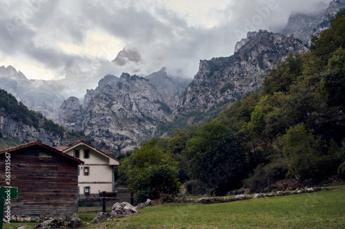 Little Houses in front of mountains whit dramatic clouds.