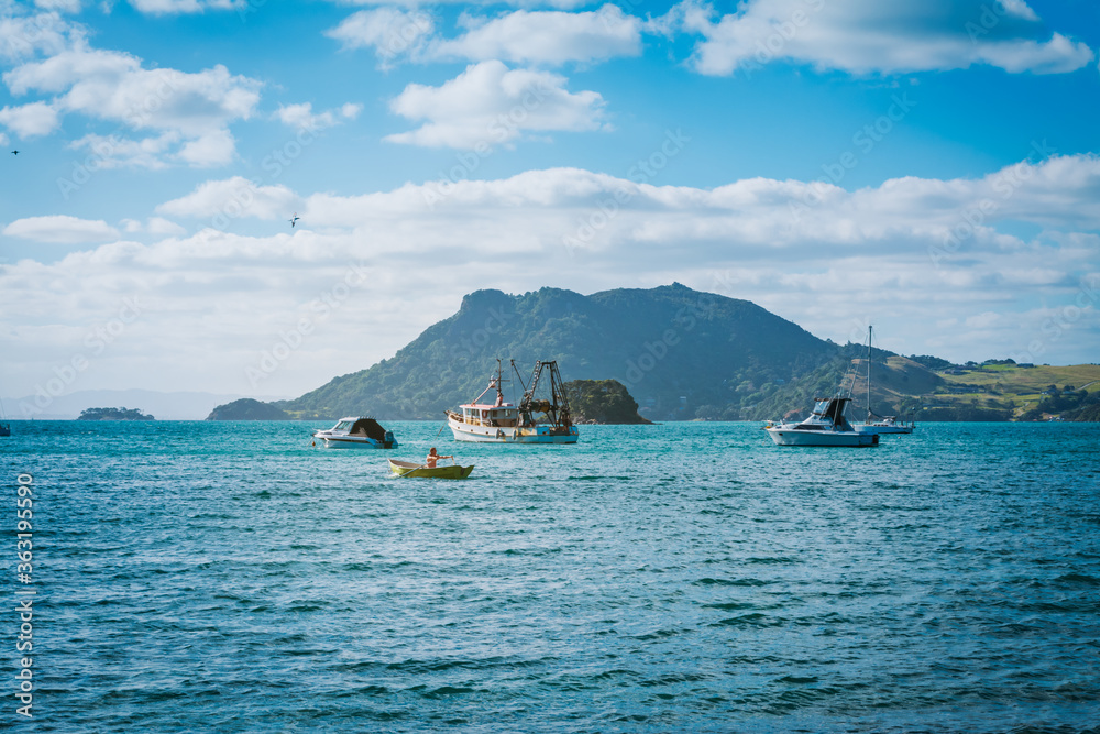 Unrecongnizable bare-chested man rows his small wooden boat towards a seiner Unrecongnizable bare-chested man rows his small wooden boat towards a seiner