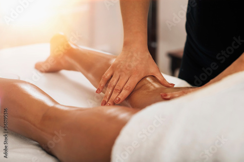 Anti Cellulite Massage. Masseuse Massaging a Female Calf photo