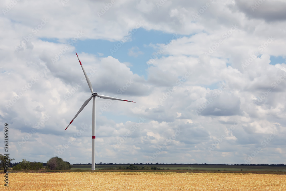 Modern wind turbine in field on cloudy day. Alternative energy source Modern wind turbine in field on cloudy day. Alternative energy source