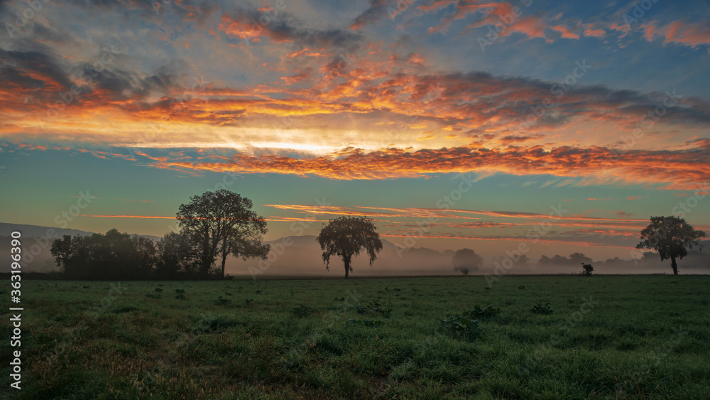 Le lever de soleil, par un petit matin brumeux, dans la campagne du Bugey, dans le département de l'Ain en Auvergne-Rhône-Alpes.
