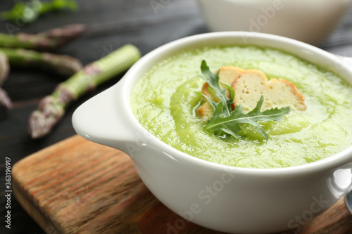 Delicious asparagus soup served on table, closeup
