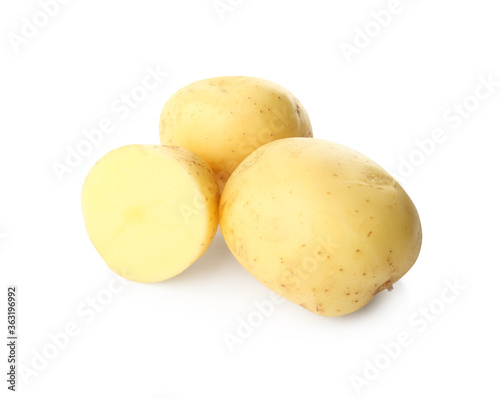 Whole and cut fresh raw organic potatoes on white background