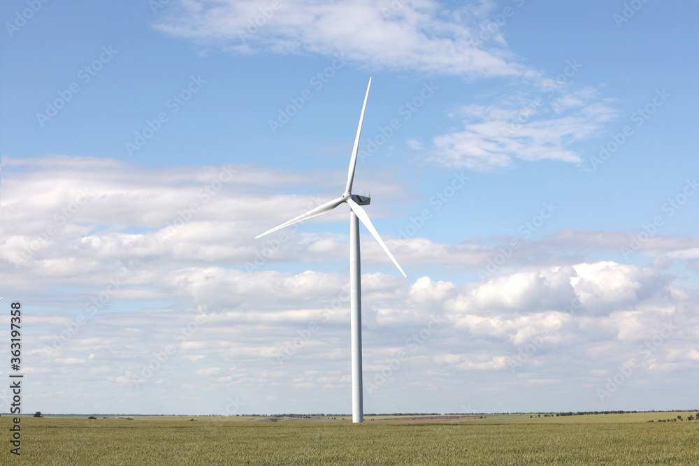 Beautiful view of field with wind turbine. Alternative energy source Beautiful view of field with wind turbine. Alternative energy source