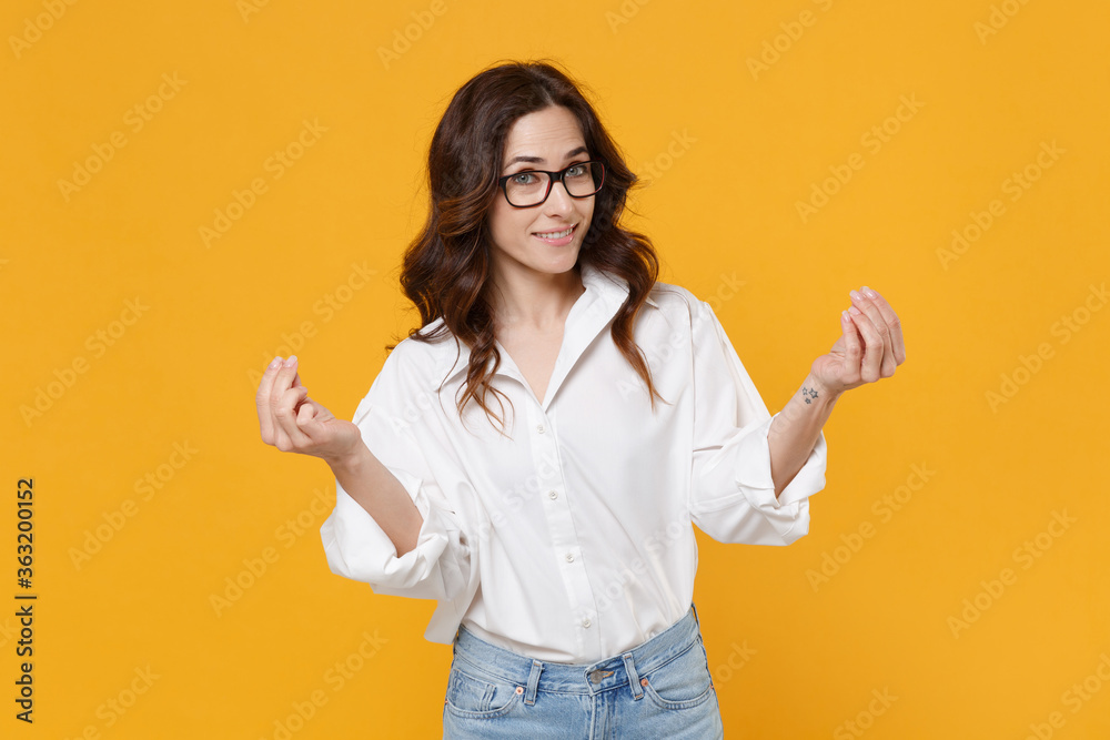 Smiling business woman in white shirt glasses isolated on yellow wall background. Achievement career wealth business concept. Mock up copy space. Rubbing fingers showing cash gesture asking for money. Smiling business woman in white shirt glasses isolated on yellow wall background. Achievement career wealth business concept. Mock up copy space. Rubbing fingers showing cash gesture asking for money.