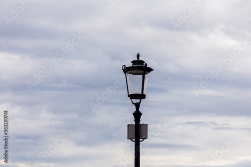 Modern vintage-style LED street lamp against a cloudy sky