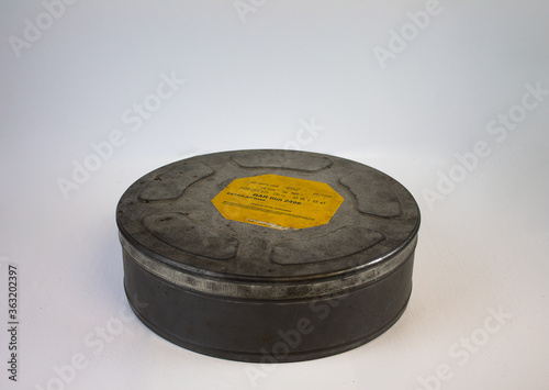 An original old film can with an orange label. For 16 mm film rolls.