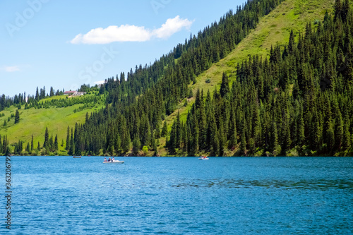 Beautiful view to Kolsai or Saty lake with mountains background. Summer vacation concept. Scenic travel background. Travel in Kazakhstan concept.