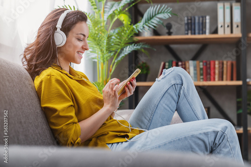 Happy young woman relaxing and listening to music using her smartphone