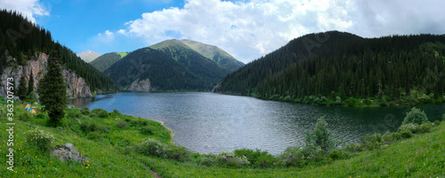 Beautiful view to Middle Kolsai or Mynzhylky lake with mountains background. Summer vacation concept. Scenic travel background. Travel in Kazakhstan concept.