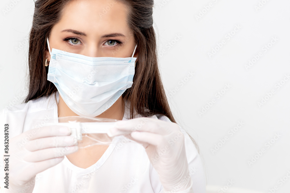 Manicure master with protective mask holding manicure nail file tool on white background Manicure master with protective mask holding manicure nail file tool on white background