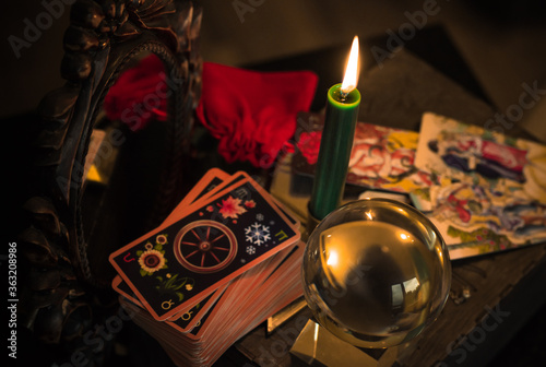 Magic crystal ball fortune teller ,love telling, esoteric concept, mystical scene with candles, tarot cards on a table