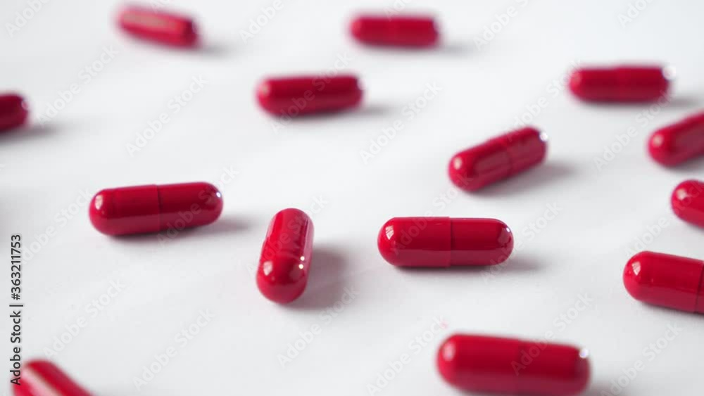 Panning red capsules on white background. Medicine close up. Panning red capsules on white background. Medicine close up.