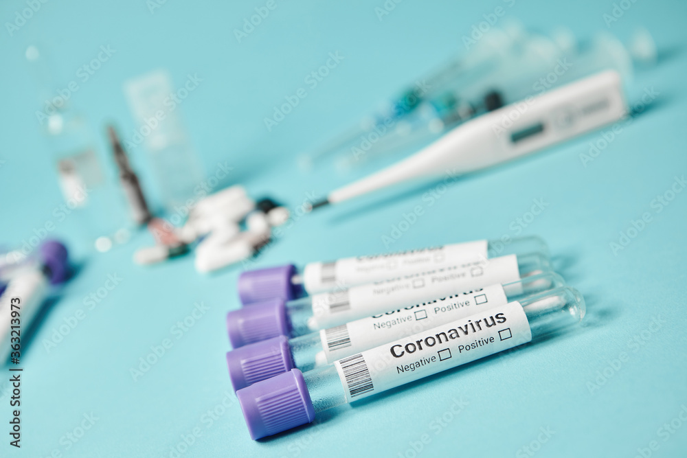 Medical test tubes with a test for coronavirus on blue background. Tests to determine the covid-19 virus.