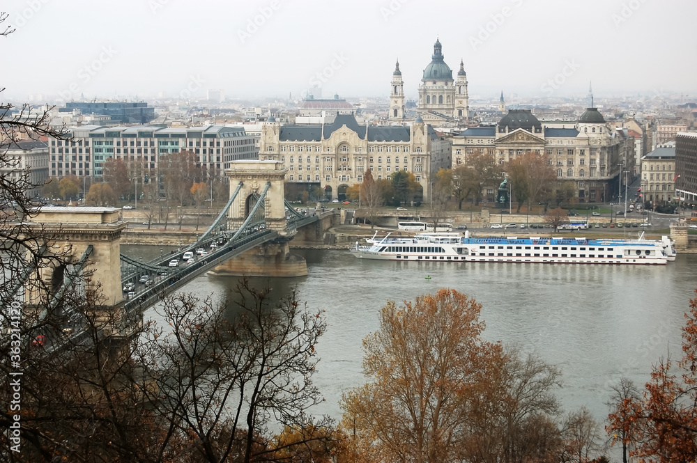 View of the Chain Bridge, Danube River and white pleasure boat in Budapest in autumn, Hungary.