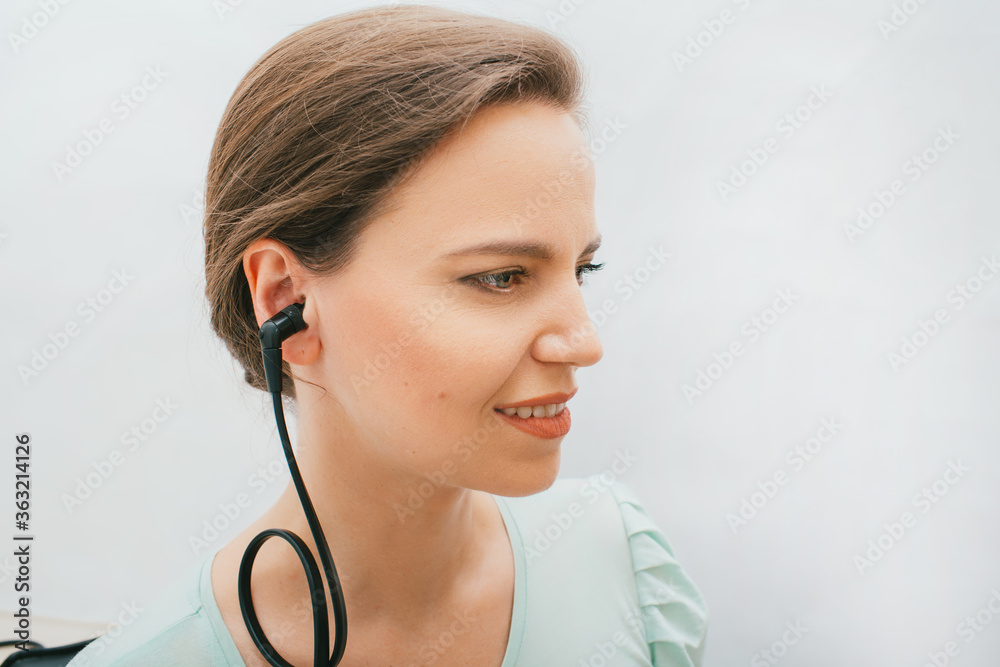 Beautiful adult woman having a hearing test with special medical equipment. Impedance audiometry, tympanometry in a hearing center Beautiful adult woman having a hearing test with special medical equipment. Impedance audiometry, tympanometry in a hearing center