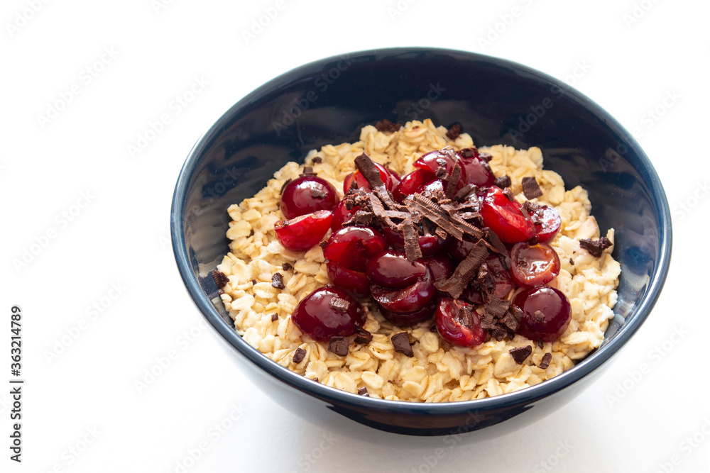 Oatmeal with cherry and chocolate in a blue bowl isolated on white background Oatmeal with cherry and chocolate in a blue bowl isolated on white background
