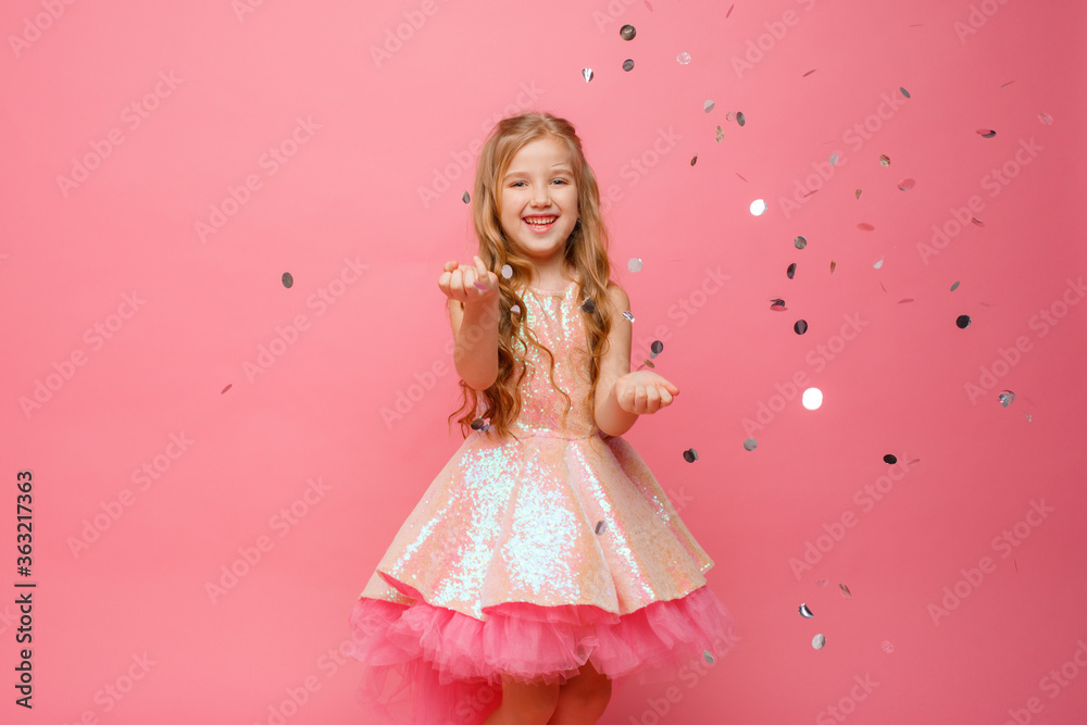 happy Little girl catches confetti on pink background, holiday concept happy Little girl catches confetti on pink background, holiday concept