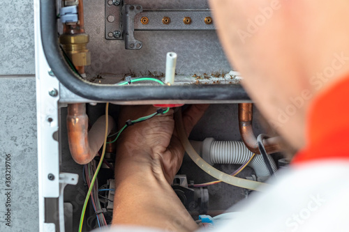 The master sets up a gas kate that weighs on the wall. The front dashboard is open. Garbage removal, cleaning, purging. Close-up