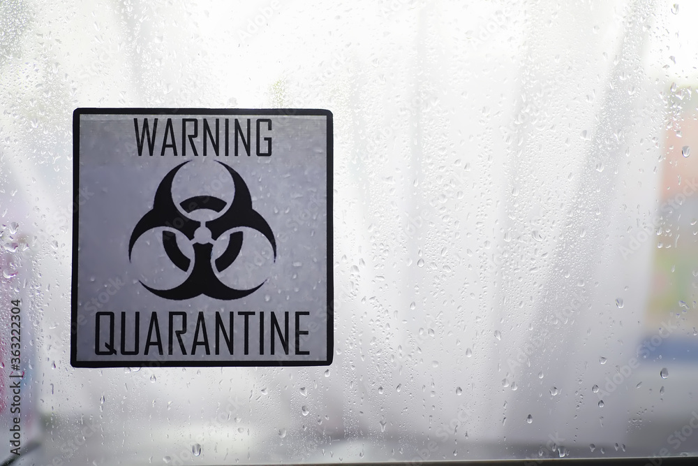 Obraz premium Quarantine. Quarantine warning sign on a glass door in a hospital isolator. Isolation of patients with the virus in special laboratories. Virus.