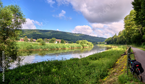 Panorama from the long-distance cycle path next to the Weser in Germany in the Weserbergland, with green banks and cloudy sky photo