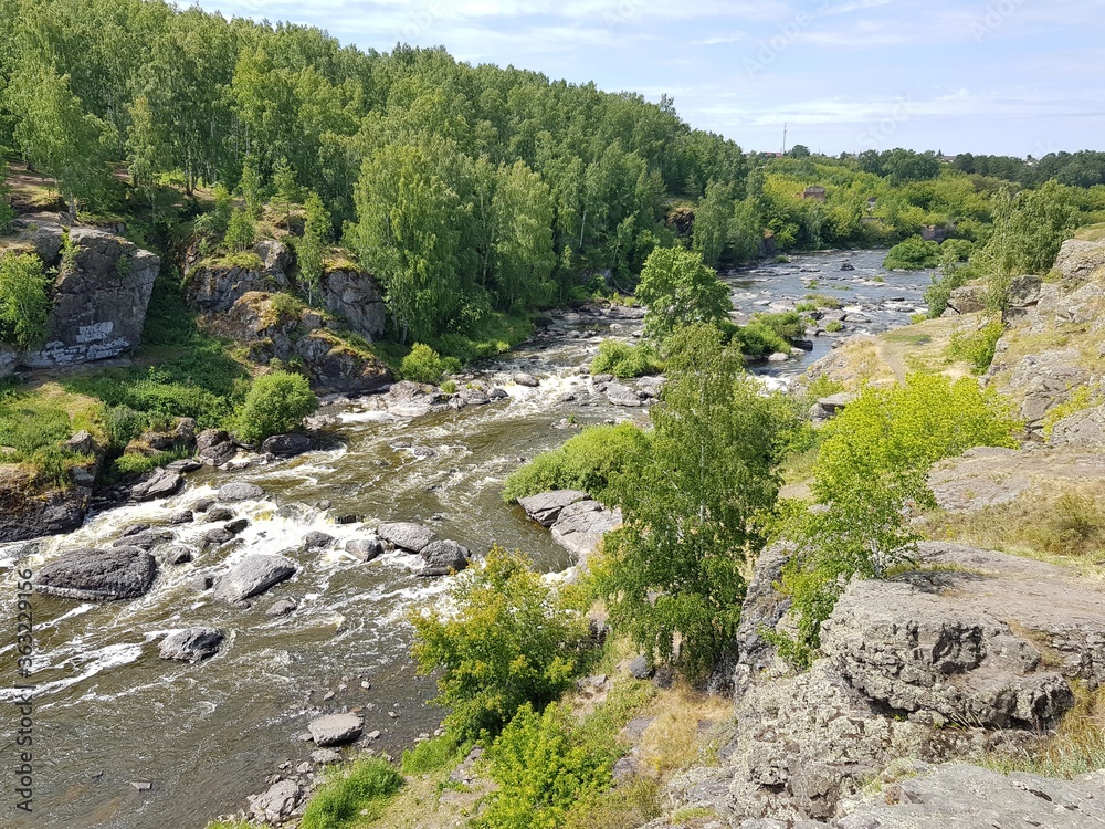 Stone boulders lie in a mountain river Stone boulders lie in a mountain river