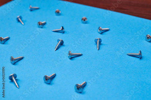 Screws scattered on a blue background.