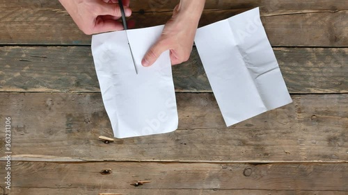 	Hands Cuts a blank white sheet of paper with scissors