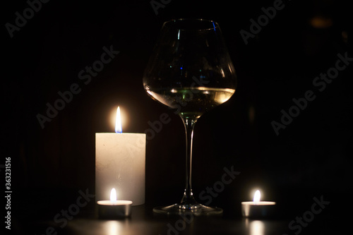 Candles and a glass of wine in the dark.