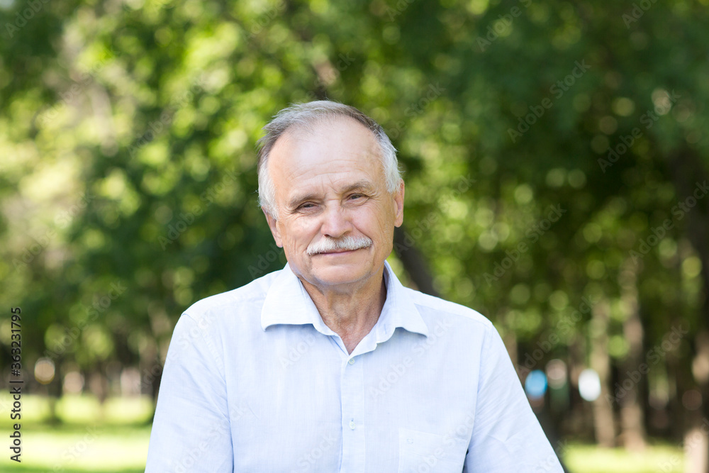 Portrait Elderly man smiling and looks in the camera outdoors Portrait Elderly man smiling and looks in the camera outdoors