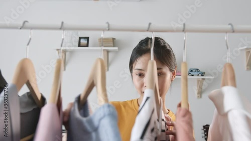Young Asian woman choose clothes in the bedroom at home.