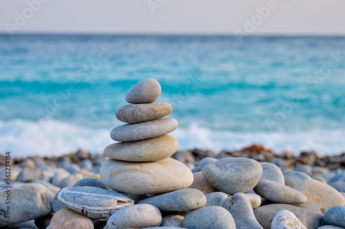 Zen meditation relaxation concept background - balanced stones stack close up on sea beach