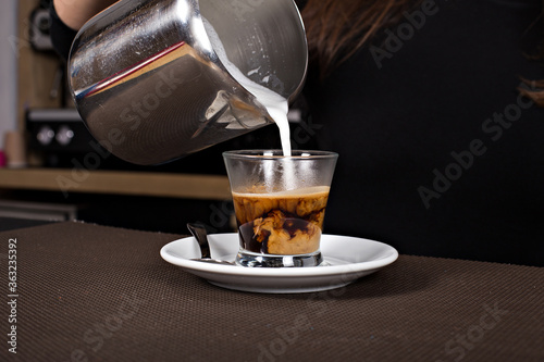 Woman pouring milk in coffee