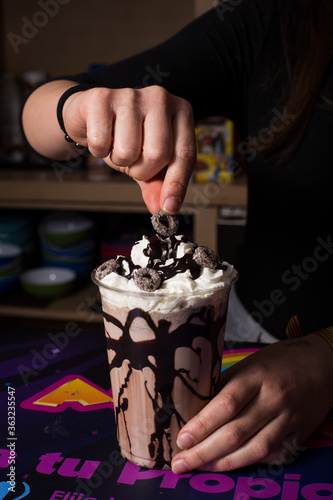 Bartender woman preparing milkshake with chocolate.
