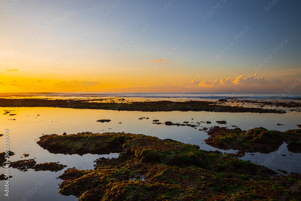 Magnificent seascape. Beach at sunset during low tide. Sunset golden hour. Sunlight reflection in water. Bingin beach, Bali, Indonesia