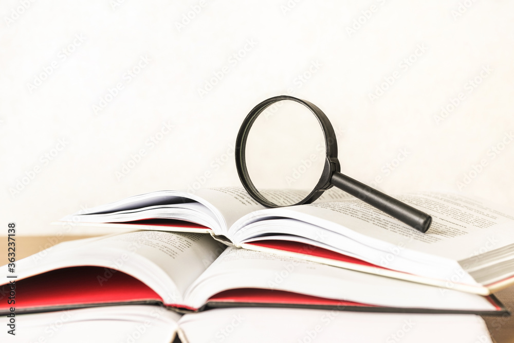 Open book with a magnifying glass. Education concept. Open book with a magnifying glass. Education concept.