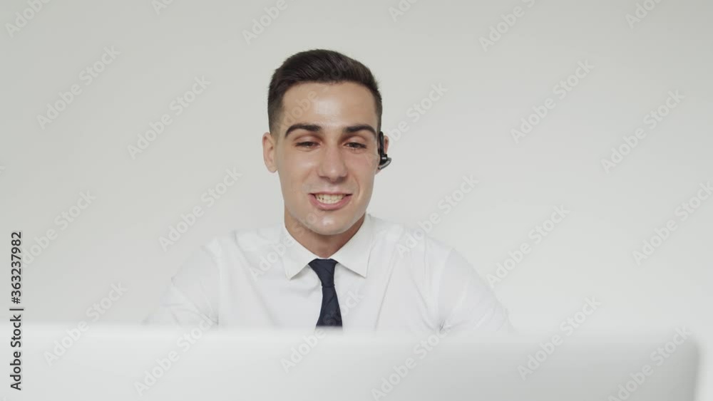 Happy student with earset passes the exam online remotely, chatting on laptop Happy student with earset passes the exam online remotely, chatting on laptop