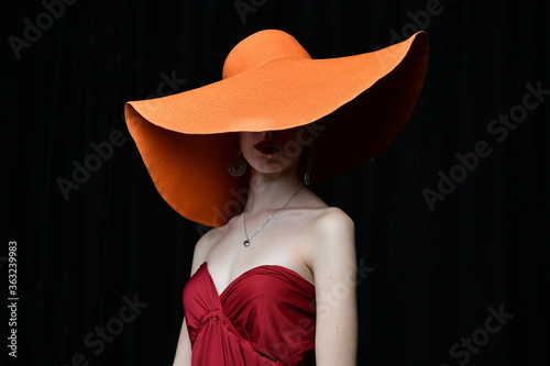 Wallpaper Mural beautiful girl in a wide-brimmed hat and in a burgundy evening dress posing on a black background Torontodigital.ca