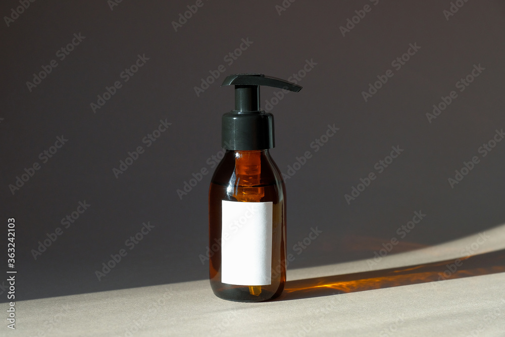 Amber glass pump bottle mockup with natural organic shampoo or hand gel soap. Beauty product packaging design with blank white label.