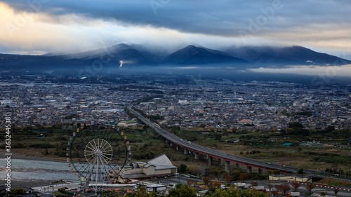 dramatic and dark process cityscape in strom and smog layer mountain background in japan