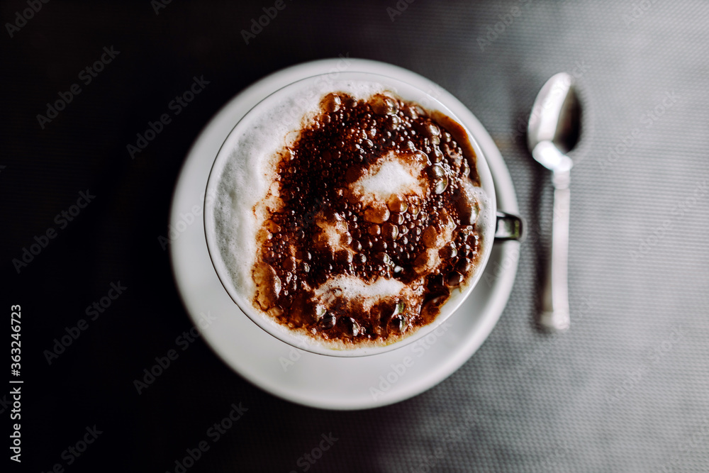 cup of coffee top view. A cup of cappuccino on dark wooden table. Morning coffee time.