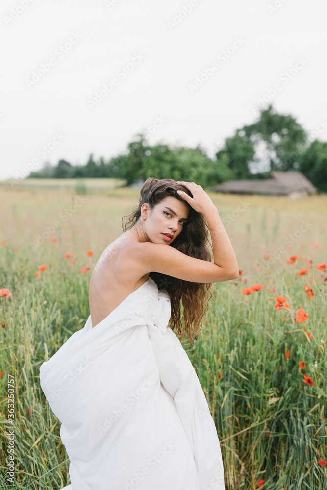 Girl wrapped in a blanket, with flowers. Stylish photo of a girl in a poppy field. Beautiful woman in a blanket in the field. Girl wrapped in a blanket, with flowers. Stylish photo of a girl in a poppy field. Beautiful woman in a blanket in the field.