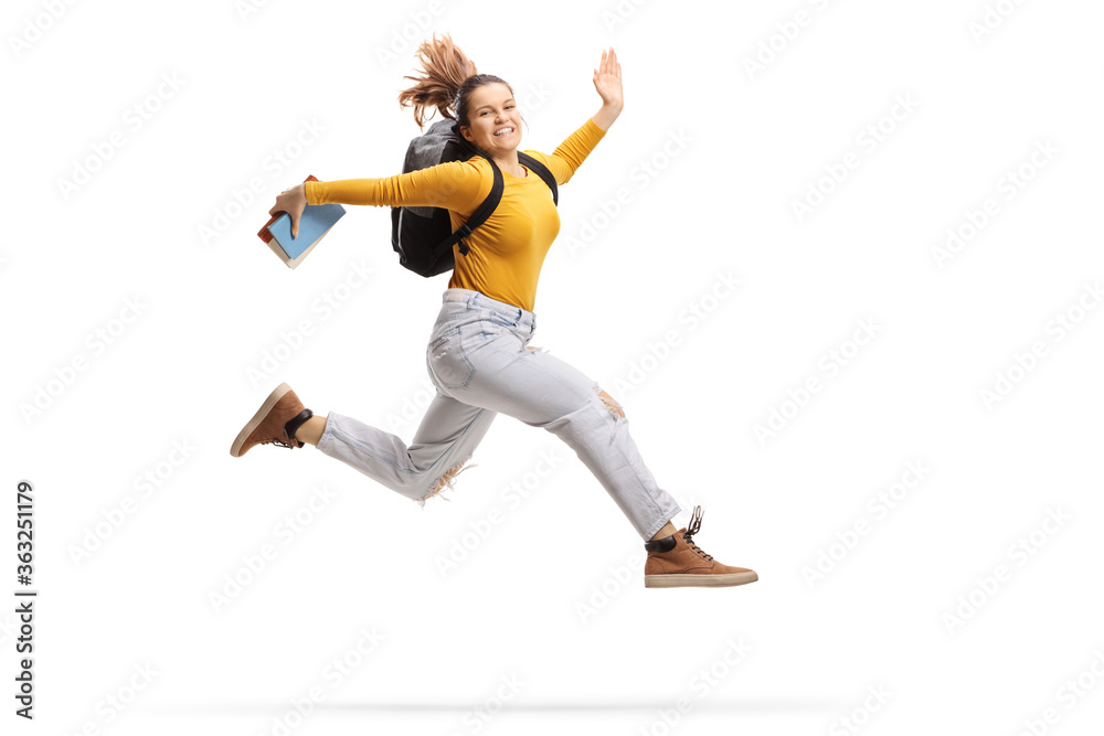 Female student holding a book and jumping high
