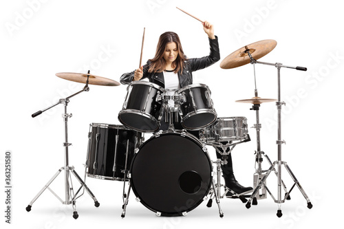 Foto Young female drummer playing drums with drumsticks