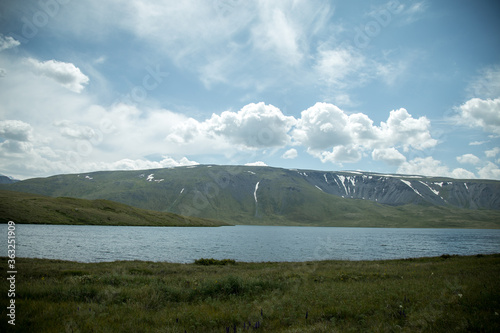 Traveling in Russia. Tour to the Altai. View of a mountain glacial lake and flowers. Radial hike. photo