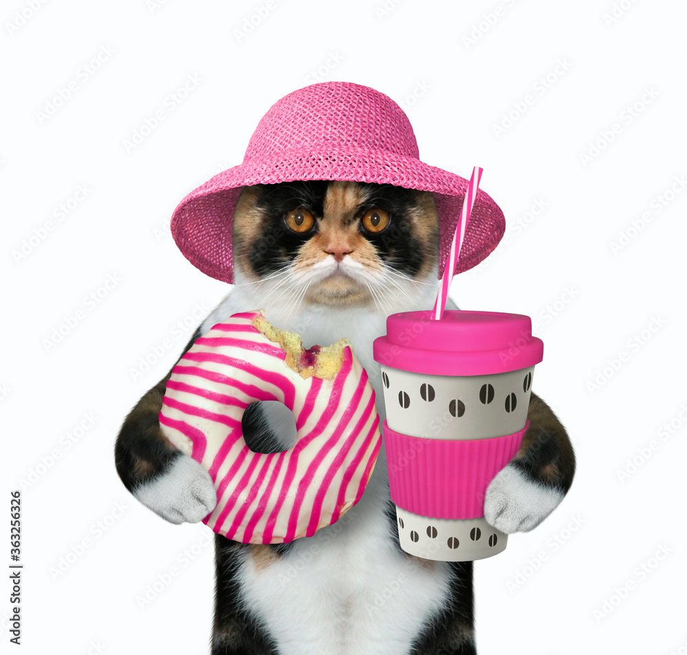 Φωτογραφία The multicolored cat in a straw hat is holding a pink striped bitten donut and a paper cup of coffee with a drinking straw