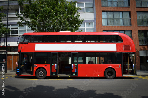 A modern London double-decker bus, spotted from the left side, with its doors open Fototapet