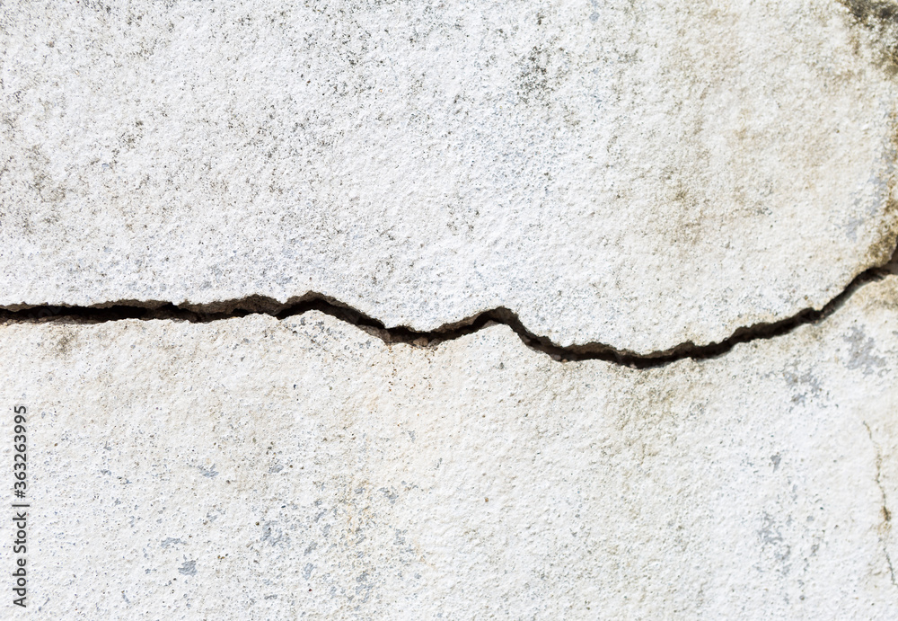 Fototapeta premium Crack white cement wall background, outdoor day light