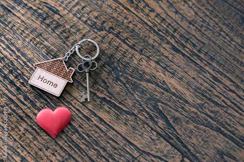 House key with home keyring on rusty wood background