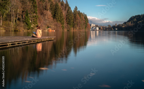 White girl reading in lakeside, Lake Bled, Slovenia